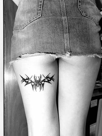 Tatuaje de araña con estilo neotribal en una pierna